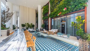 Un espace intérieur moderne doté d’un long bar, d’un coin salon et d’un jardin vertical.