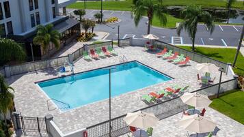 Alberca al aire libre, sombrillas en la alberca y camastros