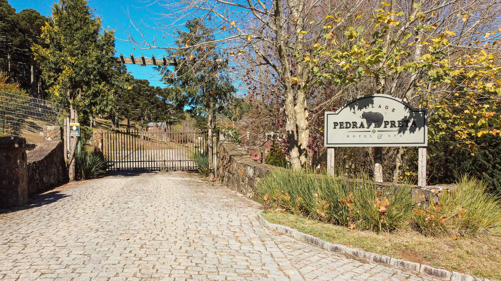 Una entrada empedrada a una propiedad con un letrero que dice "PEDRA FORTA HOTEL & SPA".