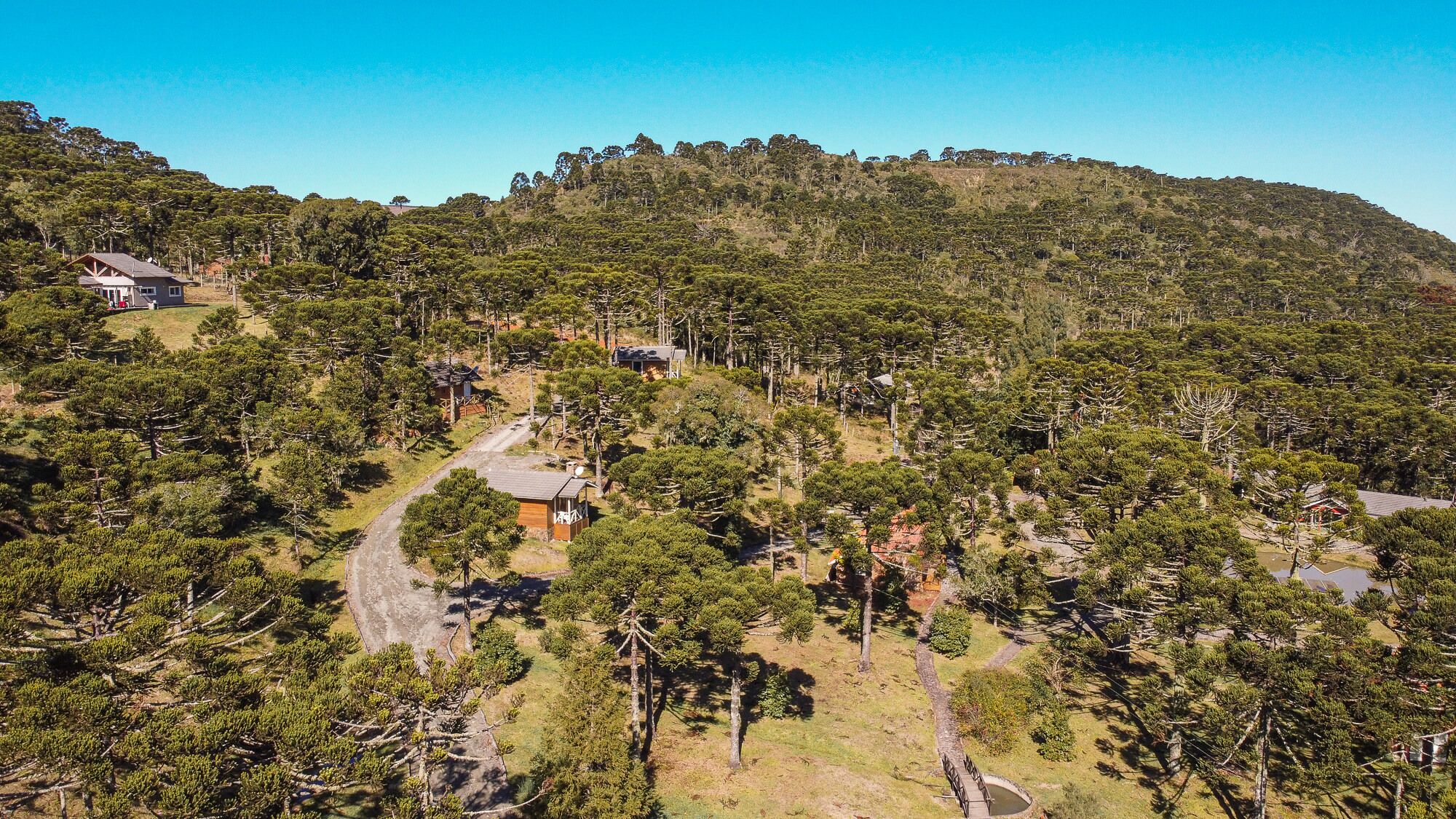 Paisagem acidentada com edifícios dispersos e densa vegetação.
