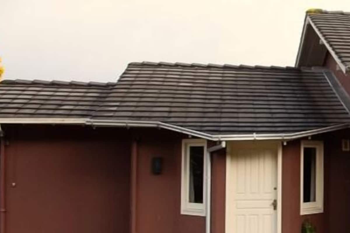 Un immeuble de deux étages, doté d’une façade brun foncé et d’un toit gris.