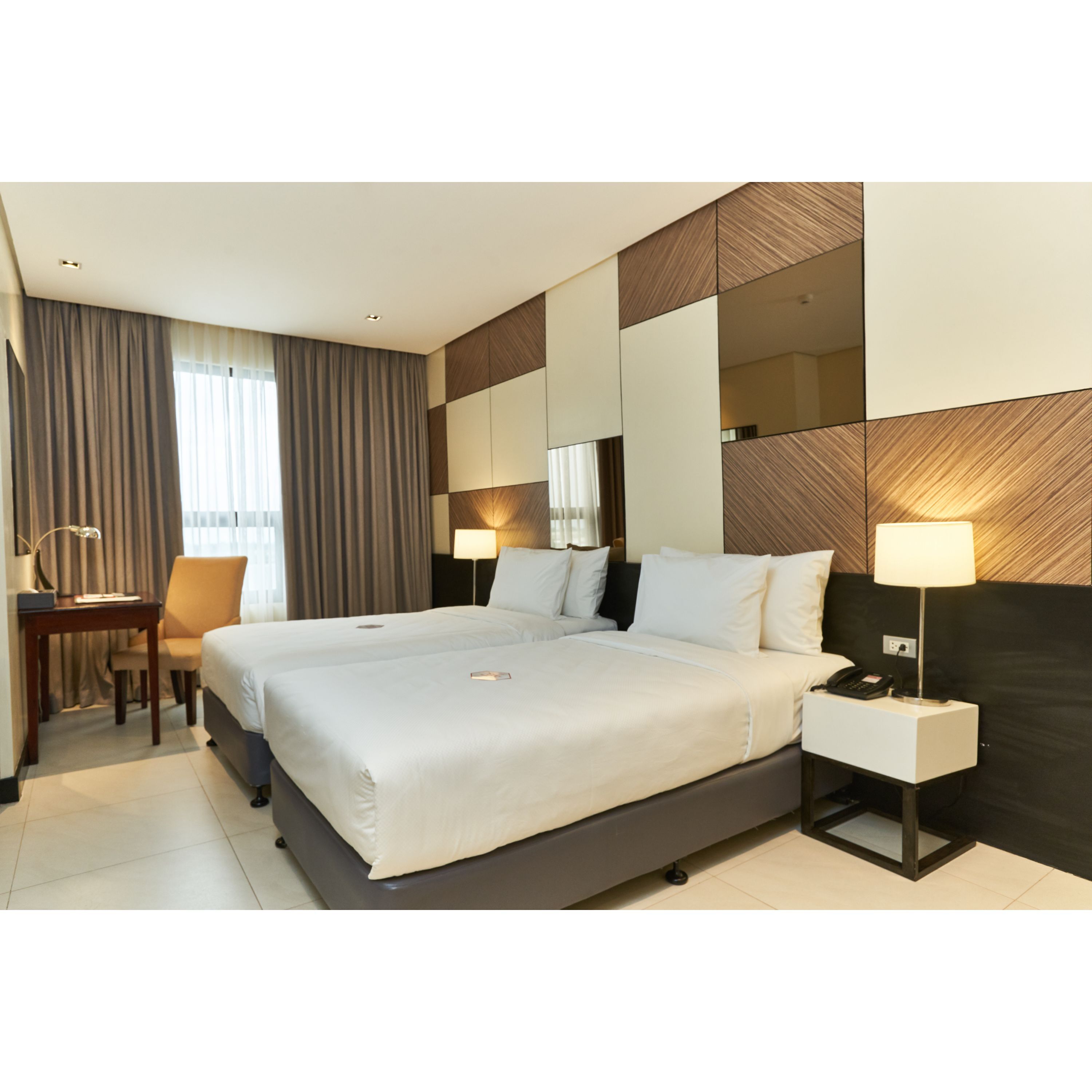 Ein Hotelzimmer mit einem großen Bett, Nachttischen, einem Schreibtisch und einem Sessel.