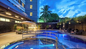 A swimming pool with a tiled deck, lounge chairs, and a palm tree in the background. - Summit Hotel Tacloban (Tacloban)