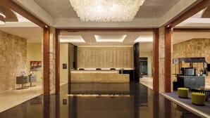 A spacious lobby with a polished floor, a reception desk, a chandelier, and a coffee station. - Summit Hotel Tacloban (Tacloban)
