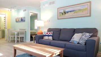 Relax in this stylish living room with a sofa, coffee table, and dining area.