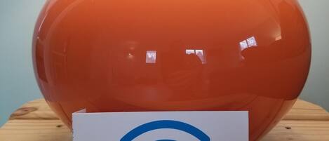 Et WiFi-symbol på et skilt foran en orange vase.
