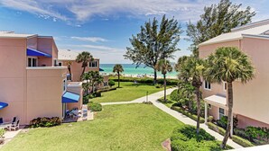 A hotel with a view of the beach, palm trees, and a clear sky. - Unit #305 Sand Cay Beach Resort Gulf View (Longboat Key)