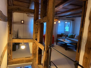 A rustic wooden interior with exposed beams, a sofa, and a table. - Superior Family Apartment in old house  built in 1707 (Laufen-Uhwiesen)