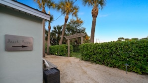 A sign indicating beach access, a gravel path, and a hedge. - Fabulous 1br New Coastal Apt Steps to the Beach! - Unit D (Cocoa Beach)