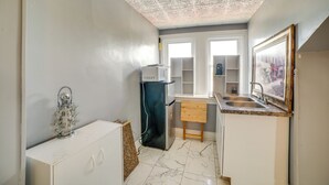 A compact kitchen with a refrigerator, a sink, and a wooden cabinet. - Pittsburgh Vacation Rental ~ 6 Mi to Downtown! (Pittsburgh)