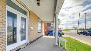 A building with a covered porch, a brick facade, and a garage door. - Pittsburgh Vacation Rental ~ 6 Mi to Downtown! (Pittsburgh)