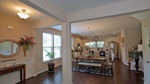 A spacious kitchen with modern appliances, a dining area with a large table and chairs, and a hallway leading to other rooms. - 3 Spacious Bedroom-Executive Town House, <br>Brand-New Construction, Duke RTP (Durham)
