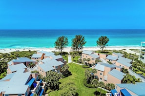 A coastal resort with multiple buildings, a beach, and a clear view of the ocean. - Unit #302 Sand Cay Beach Resort Gulf Front (Longboat Key)