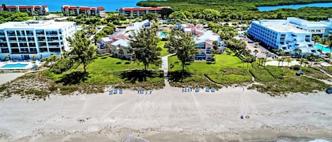 A resort with multiple buildings, a beach, and ocean views.