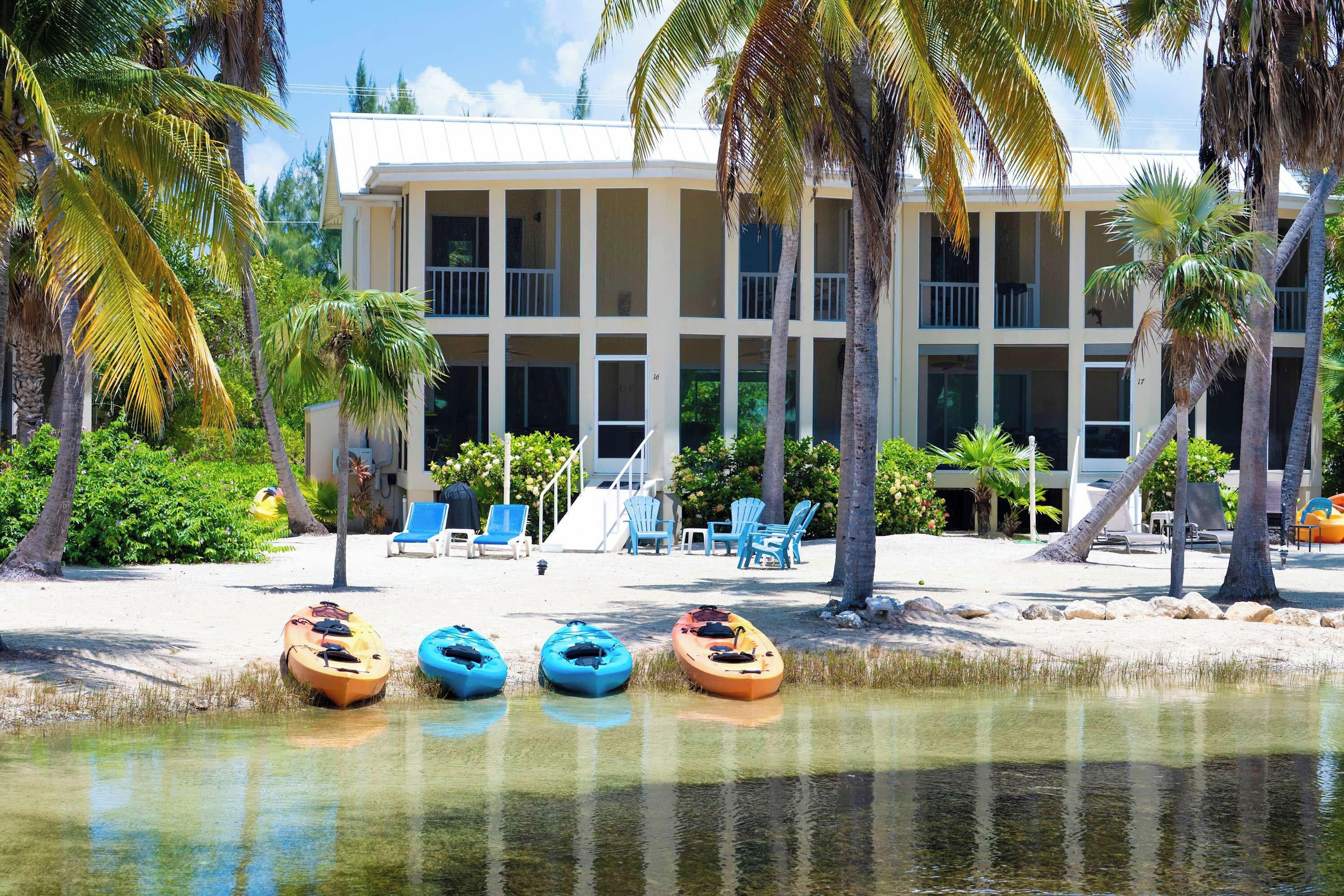 Un hôtel situé en bord de mer, doté d’une architecture à plusieurs étages, d’un espace extérieur aménagé et de kayaks disponibles sur la plage.