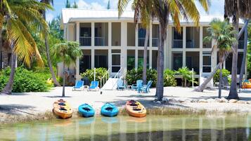 Un hôtel situé en bord de mer, doté d’une architecture à plusieurs étages, d’un espace extérieur aménagé et de kayaks disponibles sur la plage.