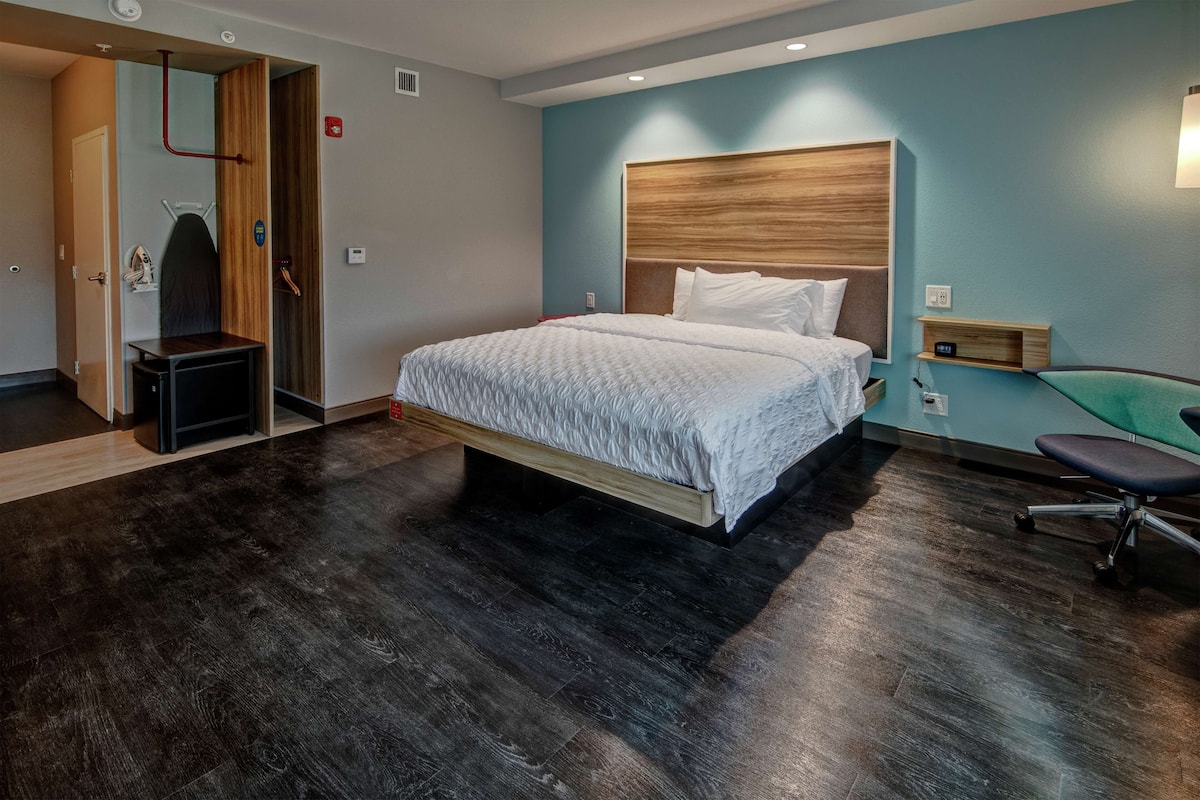 Ein modernes Hotelzimmer mit einem großen Bett, einem Schreibtisch und einem Sessel.