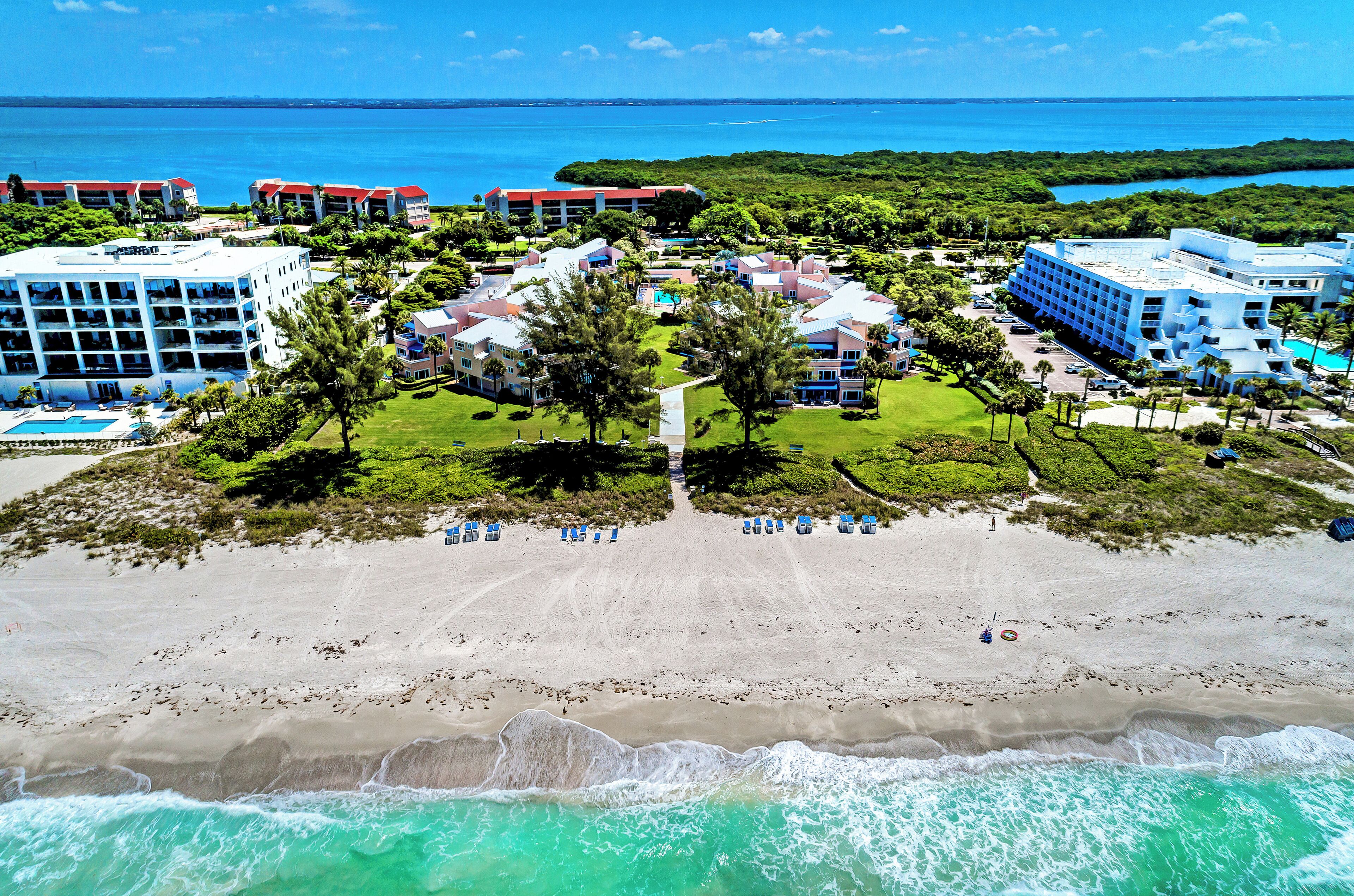 A resort with multiple buildings, a beach, and ocean views.