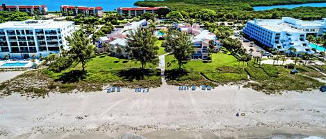 A resort with multiple buildings, a beach, and ocean views.