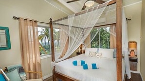 A four-poster bed with a canopy, a wooden floor, a chair, and a nightstand with a lamp. - Eagle's Base Villa & Cottage (Scarborough)