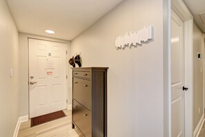A hallway with a white door, a brown cabinet, and a wall-mounted light switch.