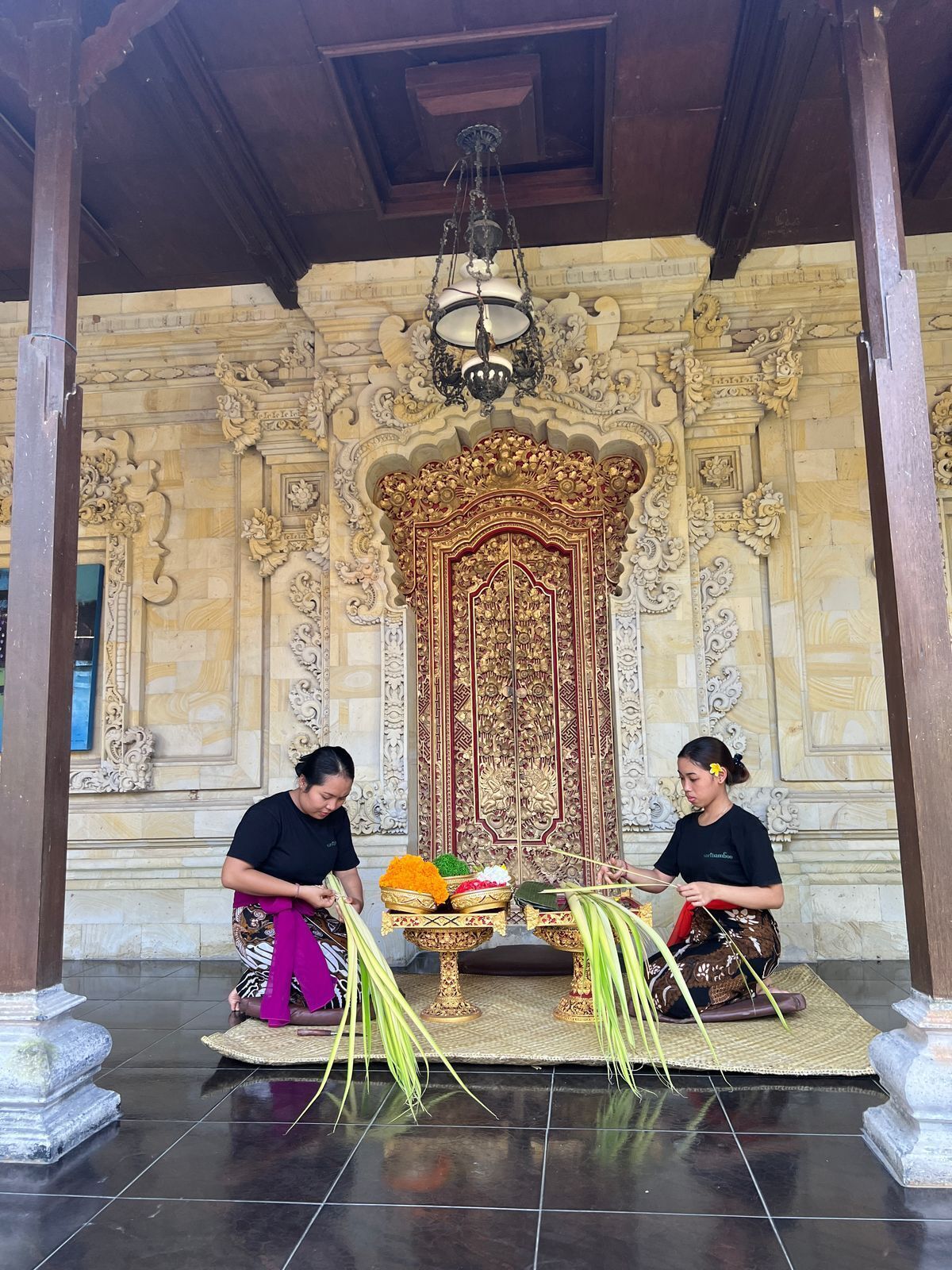 Interior ornamentado y tradicional con dos personas realizando un ritual.