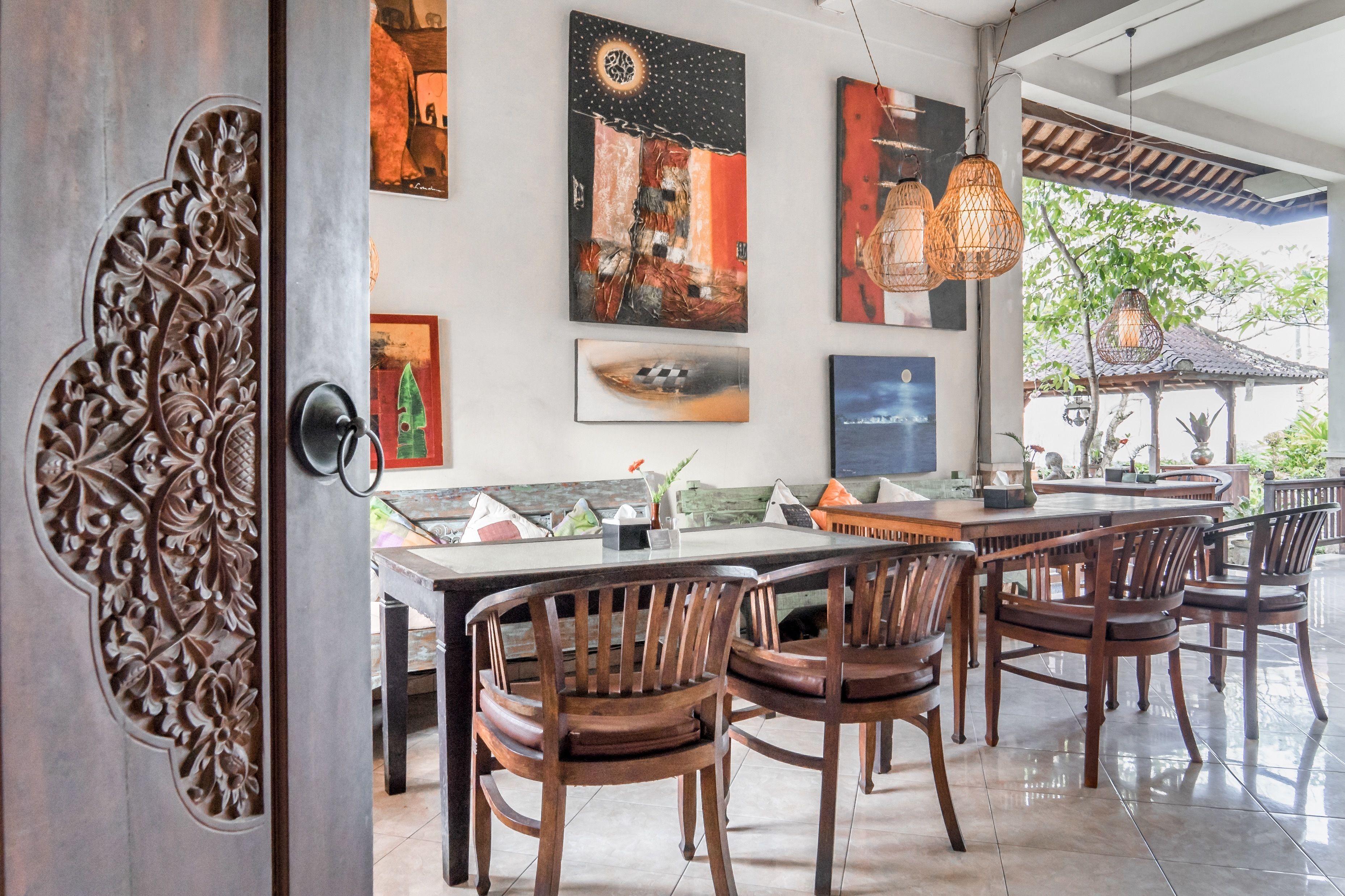 Un comedor con una mesa larga, sillas de madera y decoración en la pared.