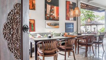 Un comedor con una mesa larga, sillas de madera y decoración en la pared.