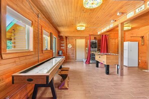 A wooden interior with a pool table, foosball table, and a sauna. - Rim Rock I Blanco, Log Cabin , Pool, Hot Tub, 10 acres of Nature to Explore (Blanco)