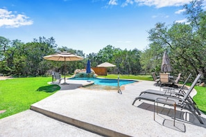 A backyard with a swimming pool, a hot tub, and outdoor seating. - Rim Rock I Blanco, Log Cabin , Pool, Hot Tub, 10 acres of Nature to Explore (Blanco)