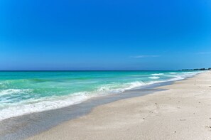 A beach with clear turquoise water and a sandy shore.