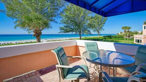 An outdoor seating area with a view of the beach and ocean. - Unit #217 Sand Cay Beach Resort Gulf Front (Longboat Key)