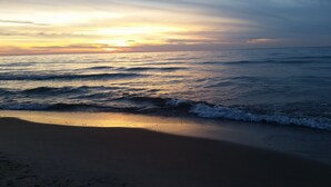 Een strand met golven en een zonsondergang.