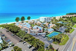 A coastal hotel with multiple buildings, a parking lot, and a tennis court. - Unit #107 Sand Cay Beach Resort Pool View (Longboat Key)