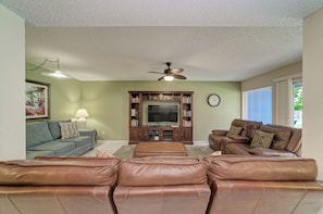 A living room with a ceiling fan, a television, and two sofas. - Unit #107 Sand Cay Beach Resort Pool View (Longboat Key)