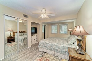 A bedroom with a bed, a television, a ceiling fan, and a wardrobe. - Unit #107 Sand Cay Beach Resort Pool View (Longboat Key)