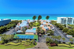 A resort with multiple buildings, a swimming pool, and a view of the ocean. - Unit #107 Sand Cay Beach Resort Pool View (Longboat Key)