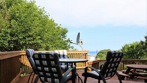 A deck with two chairs, a table, and a satellite dish. - Golfers and Beach Goers Look No Further *(New Hot Tub)* (Inverness)