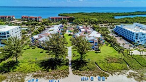Un complexe hôtelier comprenant plusieurs bâtiments, une piscine centrale et une zone de plage.