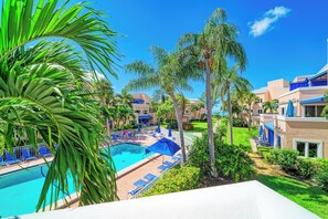 A pool area with lounge chairs and a clear blue sky.