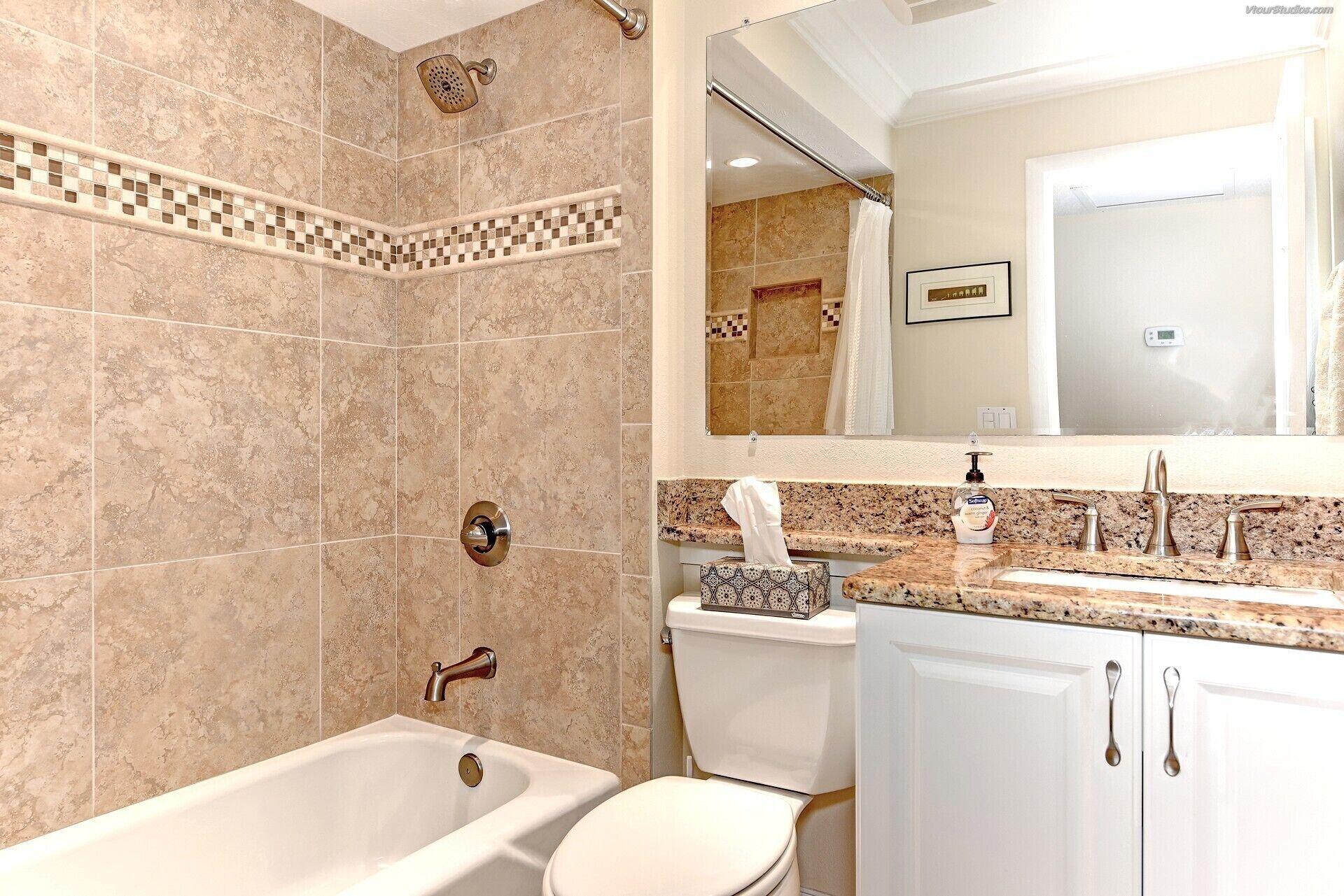 A bathroom with a bathtub, toilet, and a sink with a mirror above.