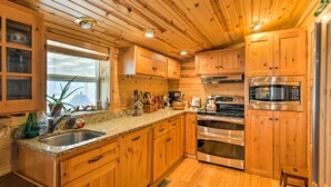 A kitchen with wooden cabinets, stainless steel appliances, and a granite countertop.