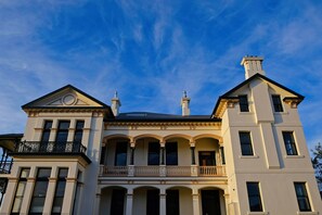 A large, two-story building with a symmetrical facade, multiple windows, and a balcony with ornate railings. - Maylands Lodge (New Town)