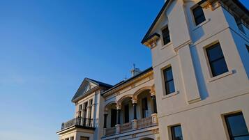 A multi-story building with a classical architectural style, featuring arched windows and balconies.