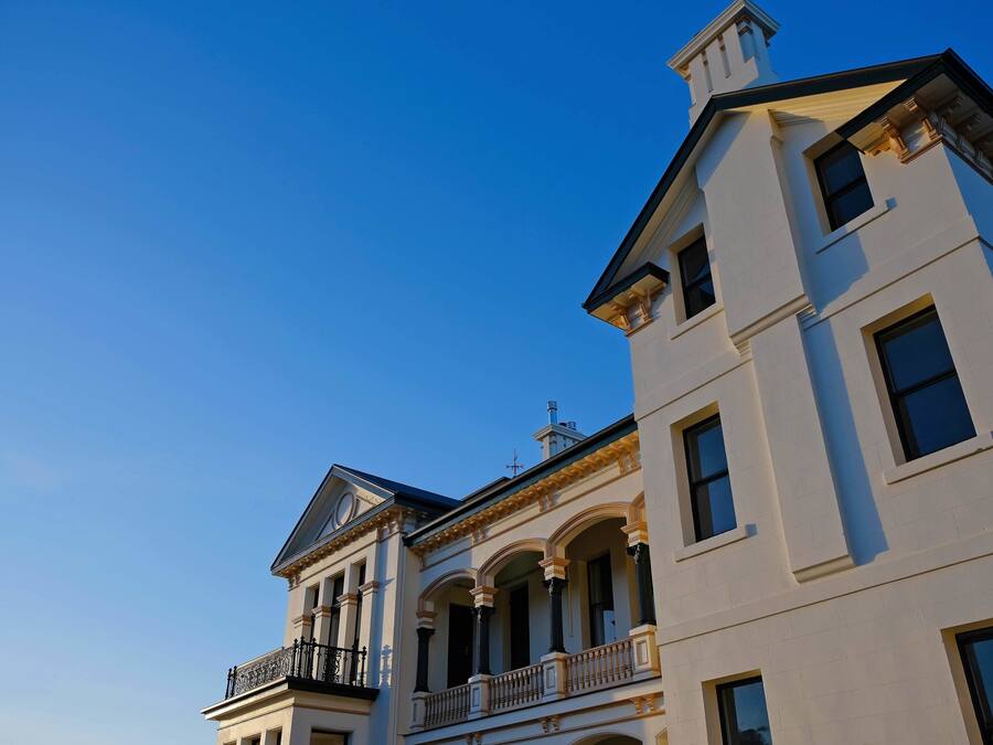 A multi-story building with a classical architectural style, featuring arched windows and balconies.