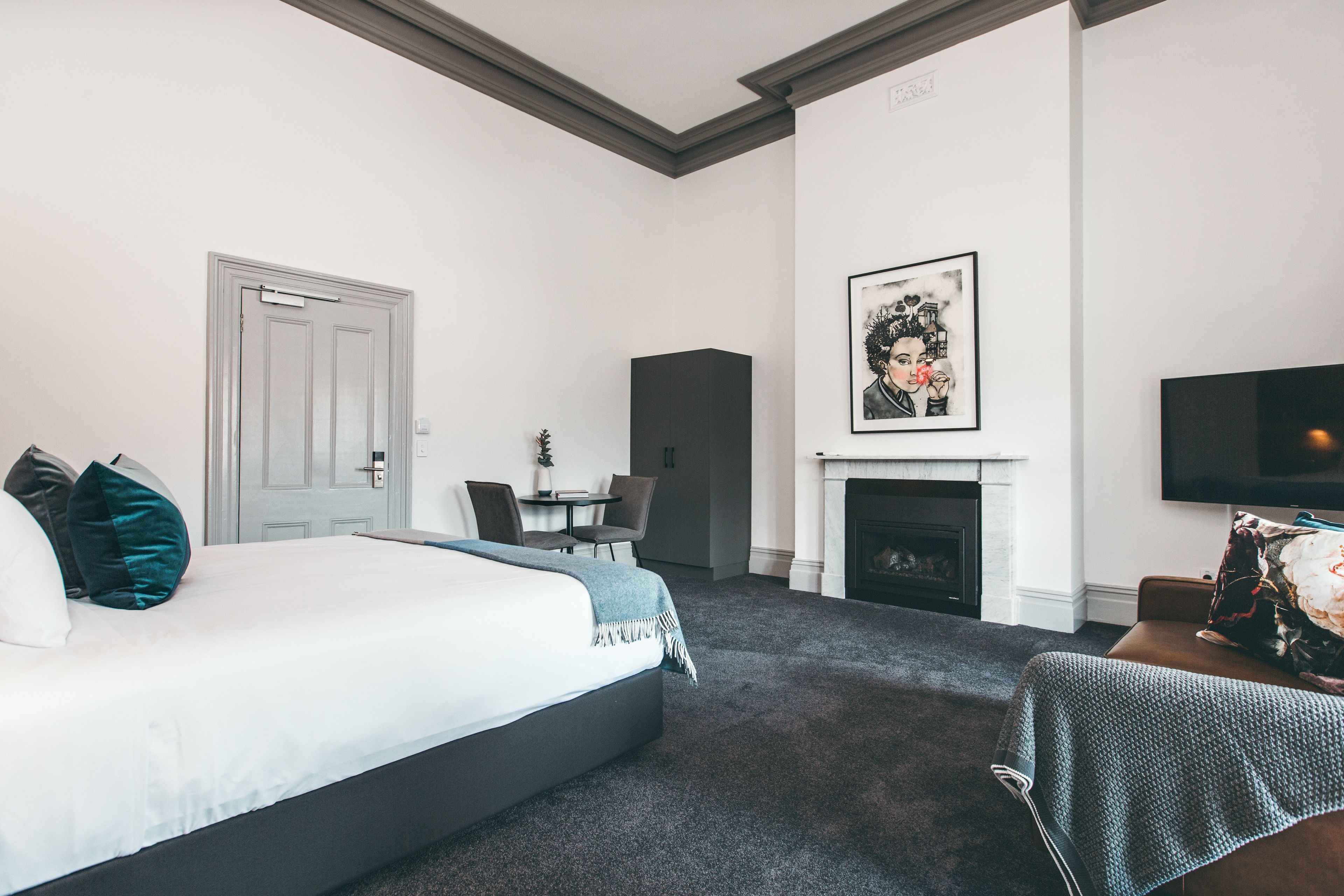Una habitación de hotel con cama, chimenea, televisión y zona de comedor.