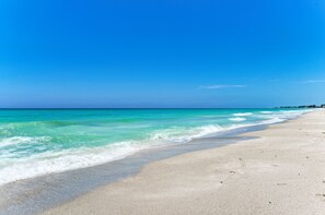 Ein Strand mit klarem türkisblauem Wasser und einem Sandstrand.