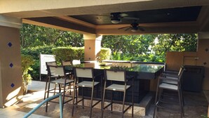 Ein Terrassenbereich im Freien mit Bar und Sitzgelegenheiten.