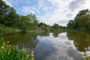 A calm lake surrounded by lush greenery and trees. - Cosy woodland retreat with private hot tub. Pet-friendly! (Forres)