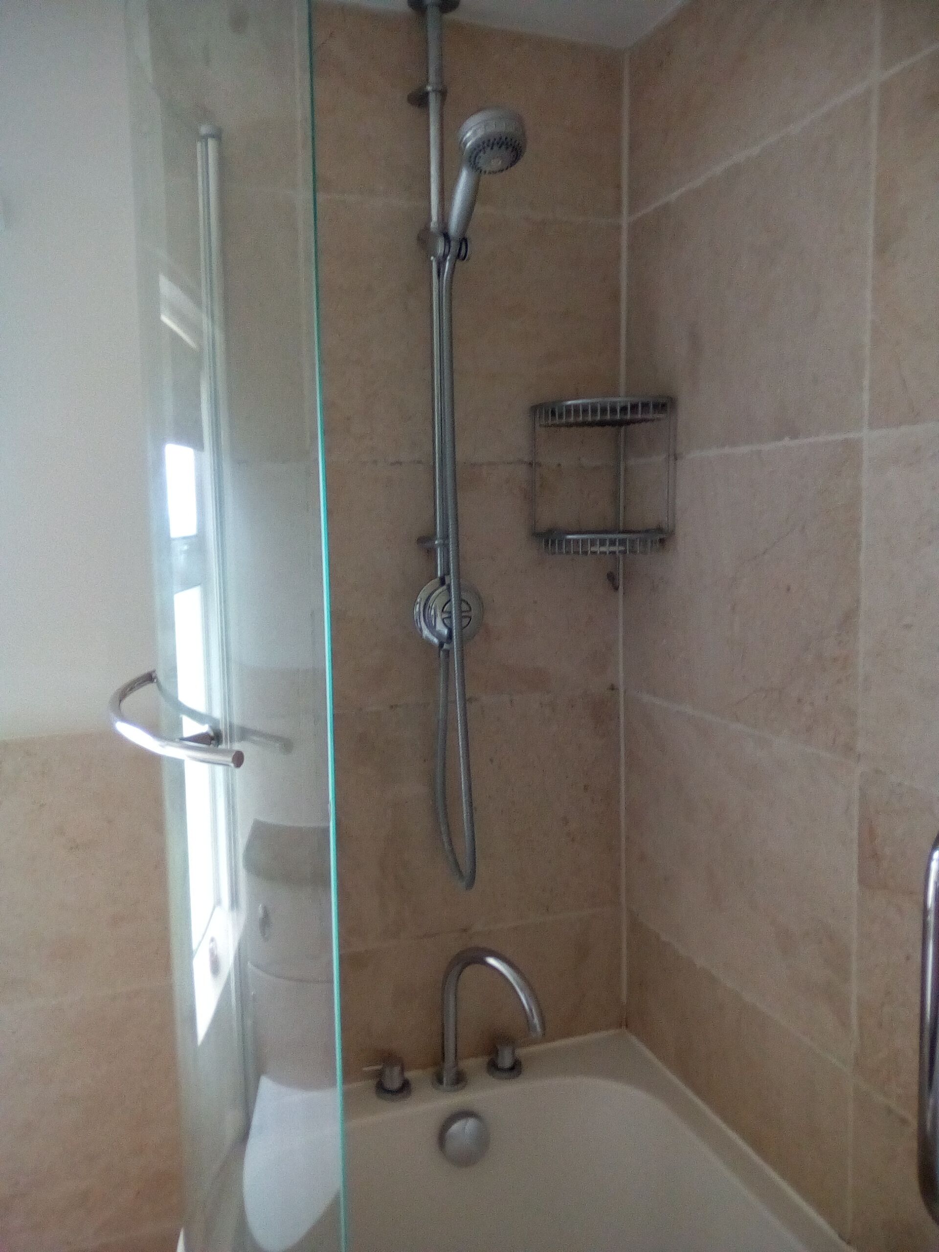 Une salle de bain avec une douche à parois de verre, une baignoire et des toilettes.